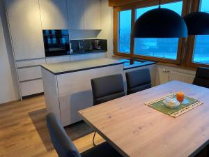 Haus Margret في ميلاو: مطبخ مع طاولة وكراسي ومطبخ مع كونتر