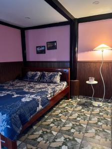 a bedroom with a bed and a table with a lamp at Sapung homestay Bảo Lộc in Blao Srê