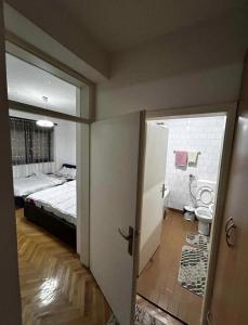 a bedroom with a bed and a bathroom with a toilet at M comfort in Kumanovo
