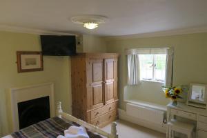 a bedroom with a bed and a dresser and a window at The Helyar Arms in Yeovil