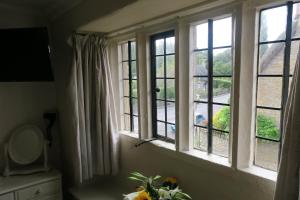 um quarto com 3 janelas com vista em The Helyar Arms em Yeovil