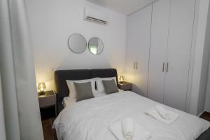 LivadhiaKalamon Luxury Suite 203 w Pool and Gym的一间卧室配有一张带两面镜子的大型白色床 更多23张照片