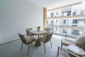 LivadhiaKalamon Luxury Suite 203 w Pool and Gym的一间设有桌椅的房间和一座建筑