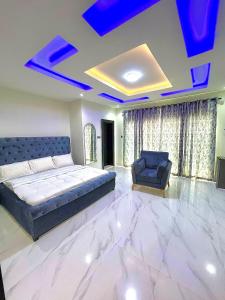 a bedroom with a bed and a couch and a chair at Fadaka Manor in Ibadan