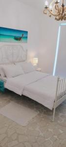 een slaapkamer met een wit bed met een schilderij aan de muur bij Liora Inside Al Dana beach Resort in Half Moon Bay +7 foto's