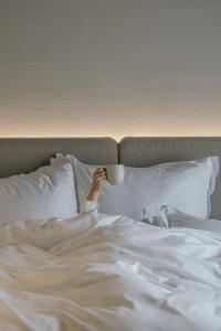 a person laying in bed holding a coffee cup at Alpvita Piz Tasna in Ischgl +37 photos
