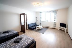 Un dormitorio con dos camas y un sofá y un televisor. en Apartmány Stdaniela, en Bohumín