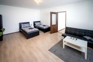 ein Wohnzimmer mit zwei schwarzen Sofas und einem Tisch in der Unterkunft Apartmány Stdaniela in Bohumín