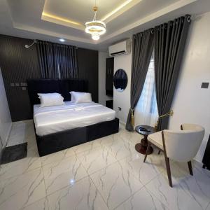 um quarto de hotel com uma cama e uma cadeira em Garnet Apartments em Iyiba mais 8 fotografias
