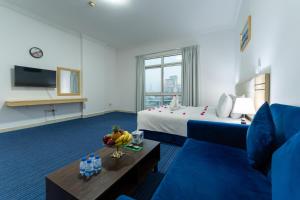 a hotel room with two beds and a blue couch at Havana Holiday Homes Oud Metha in Dubai