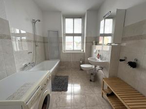 a bathroom with a tub and a toilet and a sink at Gästewohnung "Kleine Auszeit" in Halberstadt