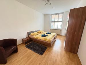 a bedroom with a bed and a chair and a window at Gästewohnung "Kleine Auszeit" in Halberstadt