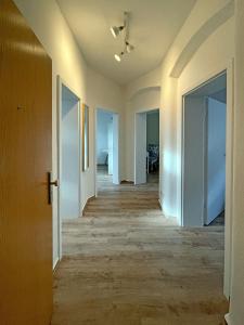 an empty hallway with white walls and wood floors at Gästewohnung "Harzliebe" in Halberstadt
