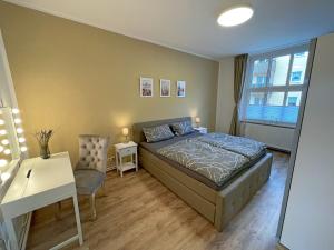 a bedroom with a bed and a desk and a window at Gästewohnung "Harzliebe" in Halberstadt
