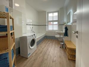 a bathroom with a washing machine and a sink at Gästewohnung "Harzliebe" in Halberstadt