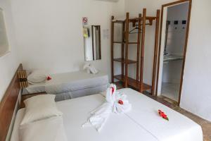 ein Zimmer mit zwei Betten und einem Spiegel in der Unterkunft Flat Flor da Terra in Itacaré + 17 Fotos