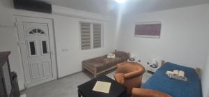 una sala de estar con un sofá y una silla en Одмориште Ноћко, en Valjevo