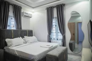 a bedroom with a large bed with a mirror and a mirror at 1 Bedroom - BFA Luxury Apartment Alagbaka Akure in Mama