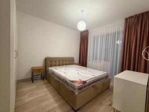 een slaapkamer met een bed in de hoek van een kamer bij Altheda Living Stejari 4B in Suceava