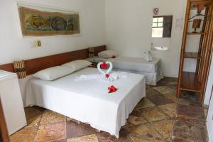 two beds in a room with two tables at Flat Flor da Terra in Itacaré