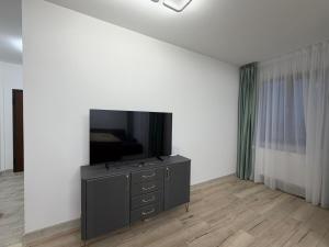een woonkamer met een flatscreen-tv op een dressoir bij Altheda Living Stejari 4B in Suceava +13 foto's
