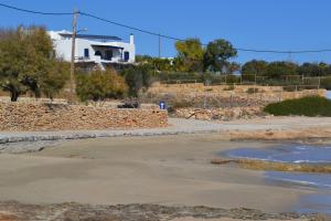 an empty parking lot with a house in the background at Anemomylos Houses in Koufonisia