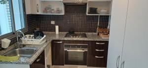 a kitchen with a sink and a stove top oven at Maison 3 in Sidi Daoud