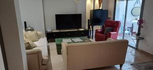a living room with couches and a flat screen tv at Maison 3 in Sidi Daoud