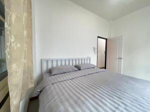 a bedroom with a bed in a white room at Haiya Holiday House 2 in Ban Hua Phrong
