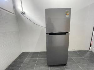 a silver refrigerator in a room with a wall at Haiya Holiday House 2 in Ban Hua Phrong
