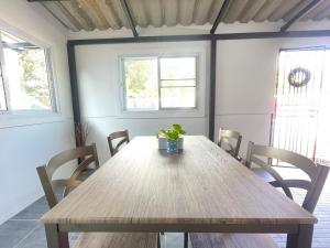 a wooden table with chairs in a room with two windows at Haiya Holiday House 2 in Ban Hua Phrong +27 photos