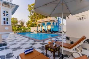 NāiAryavarta A Boutique Abode的一个带遮阳伞的游泳池