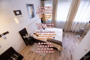 a living room with a couch and a wall with words at Hotel Borowiecki in Łódź