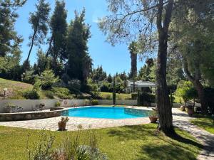 a swimming pool in a yard with a tree at Sani Villa Maria in Sani Beach