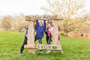a group of people standing on a sign in a field at The Mole Resort - Lodges in Chittlehamholt