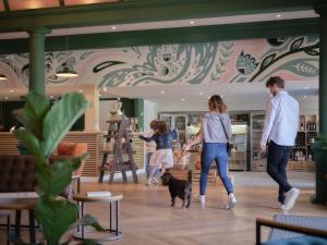 a group of people walking a dog in a lobby at The Mole Resort - Lodges in Chittlehamholt