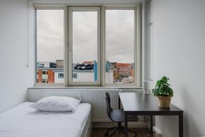 een slaapkamer met een bureau, een bed en een raam bij Copenhagen Getaway Cute Studio for Two 7 in Kopenhagen