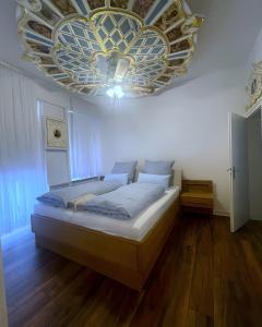 Un dormitorio con una cama grande con una lámpara de araña. en Bummelallee Schlösschen, en Bad Harzburg