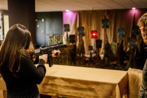 a woman holding a gun in front of a table at The Mole Resort - Lodges in Chittlehamholt