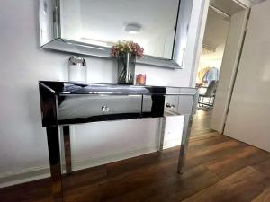 un escritorio con un jarrón de flores encima en Bummelallee Schlösschen, en Bad Harzburg 60 fotos más