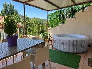 a patio with a hot tub and a table and chairs at Hubstay Hillside Residence with Private Jacuzzi in Platres