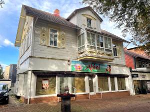 un edificio blanco con una tienda delante en Bummelallee Schlösschen, en Bad Harzburg
