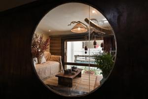 een woonkamer met een bank en een tafel in een spiegel bij RUM Studio 5 in Ho Chi Minh-stad