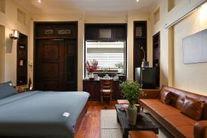 een slaapkamer met een bed, een bank en een tafel bij RUM Studio 5 in Ho Chi Minh-stad