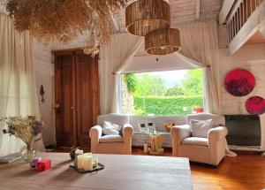 a living room with chairs and a table and a window at Casa del Cielo in La Cumbre