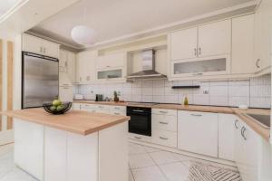 una cucina con armadi bianchi e un cesto di frutta su un bancone di Villa Zavria ad Argásion Altre 18 foto