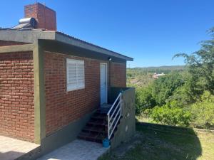 Cabañas el atardecer de Andrés - Flor Serrana - Tanti في تانتي: منزل من الطوب مع سلالم تؤدي إلى الباب