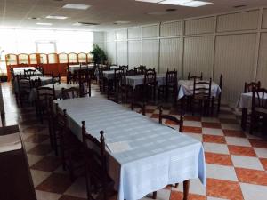 una sala da pranzo con tavoli e sedie con tovaglia bianca di Pensión San Cristóbal by Bossh! Hotels a Cuenca Altre 18 foto