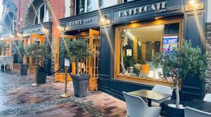 a store front with tables and chairs and potted trees outside at La Frégate in Collioure