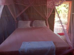 a bedroom with a large bed in a tent at Maison Des Voyageurs in Ambanja